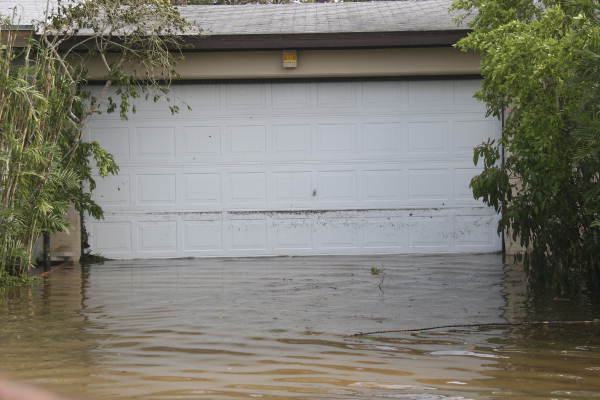 Garage door partially submerged in floodwater