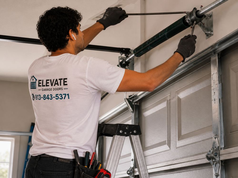 Elevate Garage Doors technician adjusting a garage door torsion spring