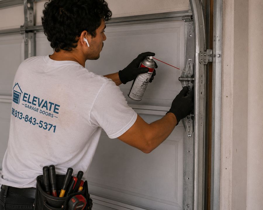 Elevate Garage Doors technician lubricating garage door hinges