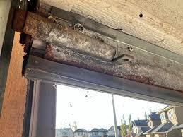 Worn and rusted weather seal retainer on a garage door