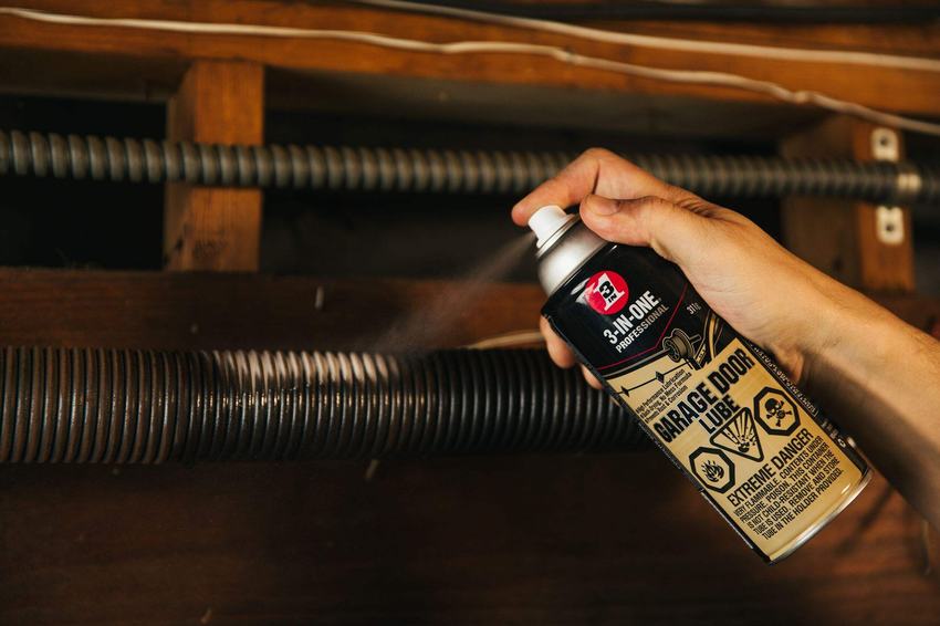 Applying garage door lubricant to a torsion spring