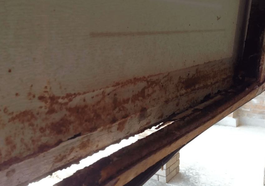 Rusted garage door frame at the bottom corner